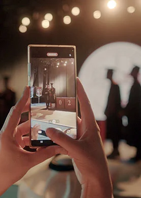 AUK student capturing moments of his friends receiving their graduation certificates at the AUK auditorium.