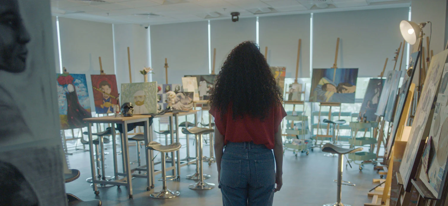 An AUK student admiring an art exhibition on campus, appreciating creative expression.