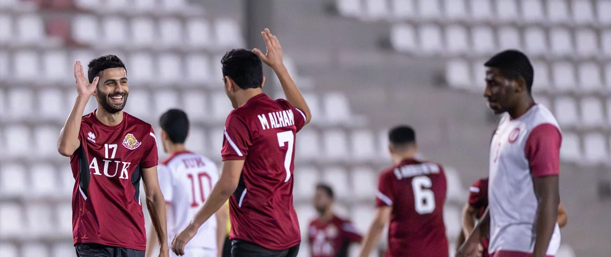 AUK football team players in action, competing with determination during a match.