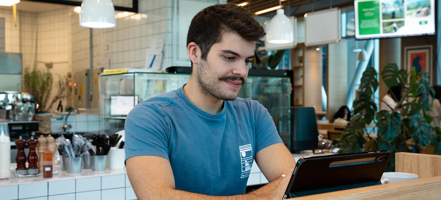 A dedicated AUK student engrossed in studying, seated in the university cafeteria.