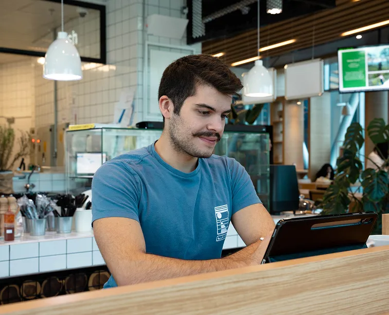 A dedicated AUK student engrossed in studying, seated in the university cafeteria.